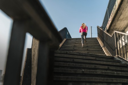 Young woman running up stairs