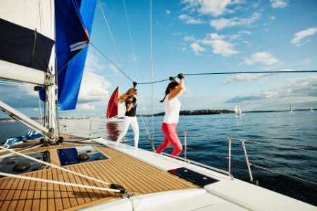 
            ヨットの上でロープを持つ女性たち
        