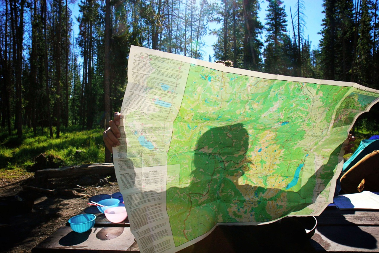 A person at a campsite holds up a large map