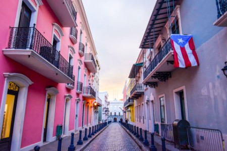 Calle en Puerto Rico con la bandera colgando de un balcón