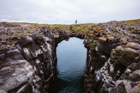Persona caminando sobre un puente natural de rocas