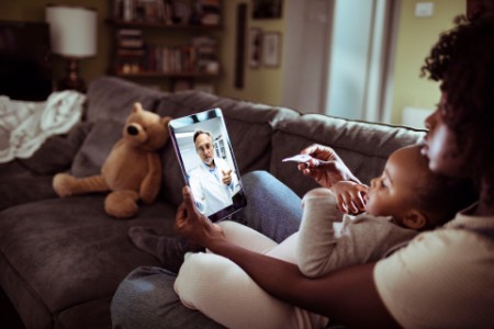 mother and daughter consulting with doctor on video call