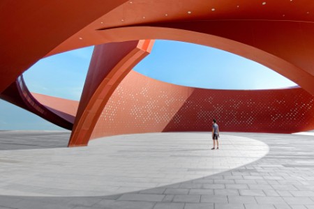 A person in a red curved abstract architectural space