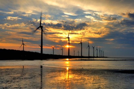 
            夕日を背景にした風力発電機
        