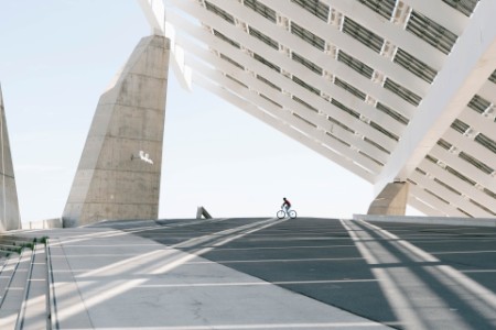 Persona montando bicicleta bajo una gran estructura de paneles solares