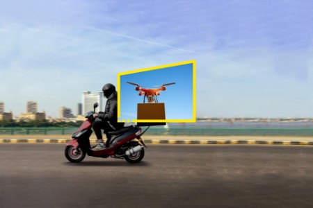 Çerçeve içinde kutu üstünde drone, dışında motosiklet ve köprü