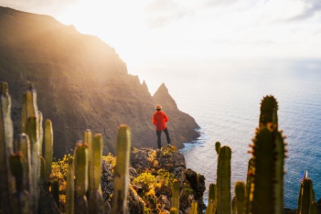Turista em pé sobre um penhasco na costa de Anaga, Tenerife, Espanha