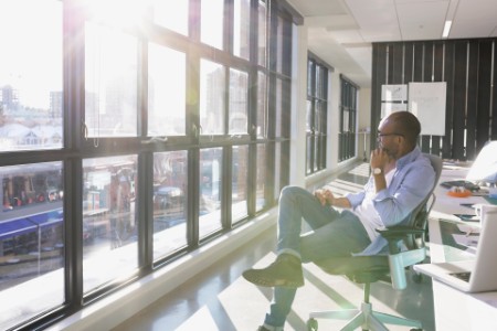 businessman looking out sunny office window