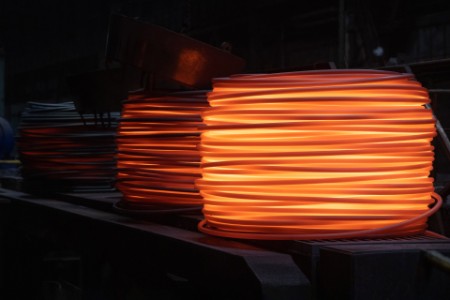Coils of red hot steel in a factory