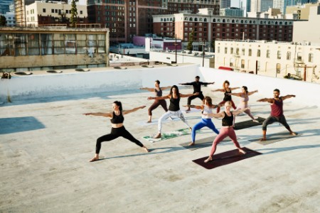 Elevated view of yoga class on rooftop overlooking city