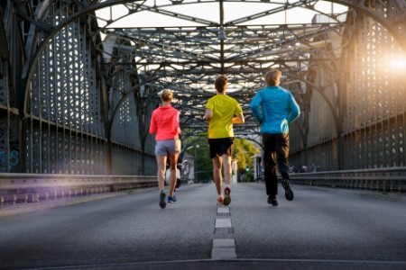Friends jogging on bridge, Munich, Bavaria, Germany