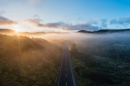 Mountain road in the fog at sunset