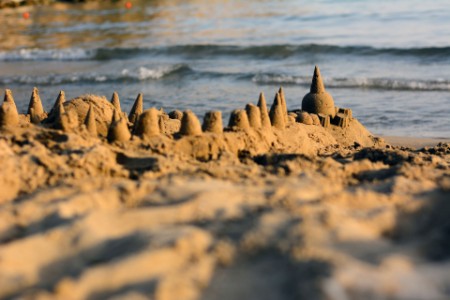 Castillos de arena en la playa mientras sube la marea