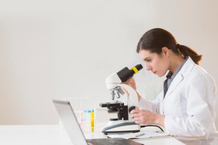 Scientist looking through microscope