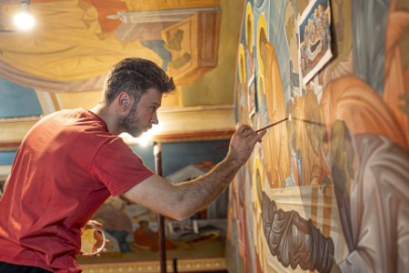壁画を描く若い男性アーティスト