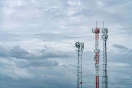 Low angle of telecommunications towers against sky