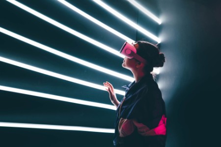 girl using vr goggles in colorful neon lights