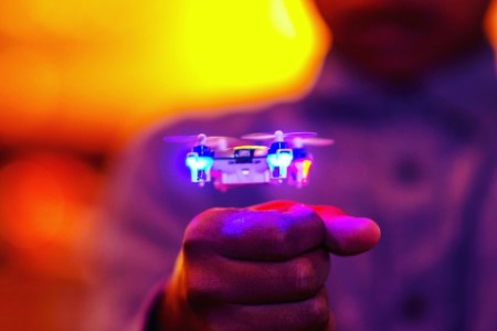 Midsection of man gesturing by illuminated drone flying
