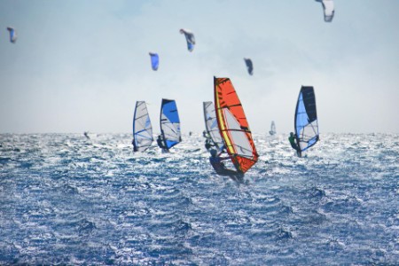 Windsurfistas y kiteboarders en el mar picado