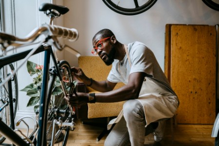 Proprietário masculino consertando bicicleta na oficina