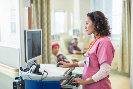 Female doctor using computer in infusion room