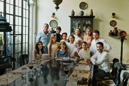 Portrait of multigenerational family gathered at dining room table for birthday dinner