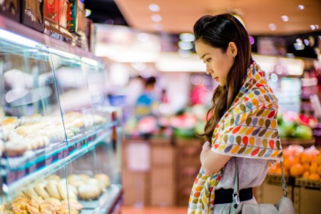 woman looking supermarket bakery display