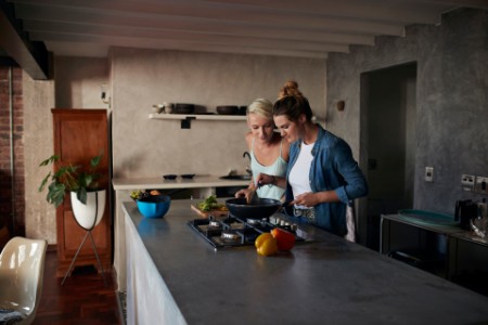 Women cooking together in loft apartment