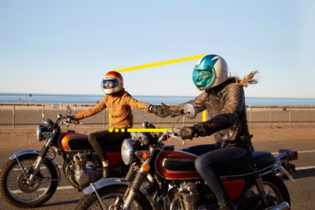 Dos mujeres montando motocicletas en un camino vacío