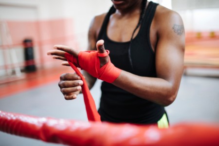 Female boxer wrapping her hands ready for training