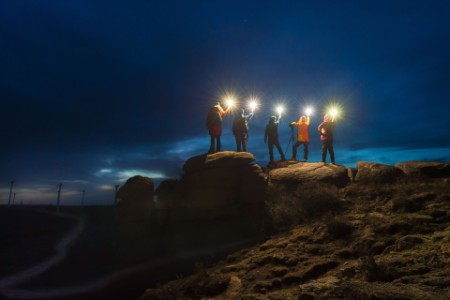 Group of photographers stand on the stone with lamp at night