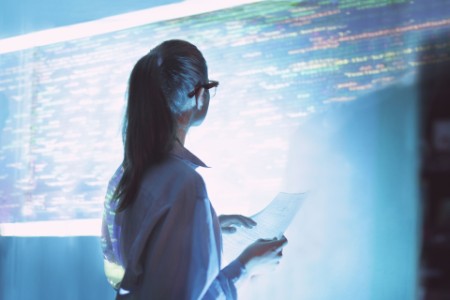 Woman looking at projected code on office wall