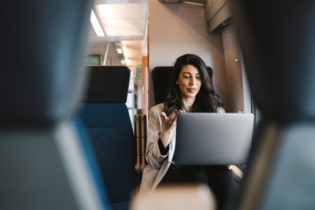 Young woman talking on her laptop on board a train