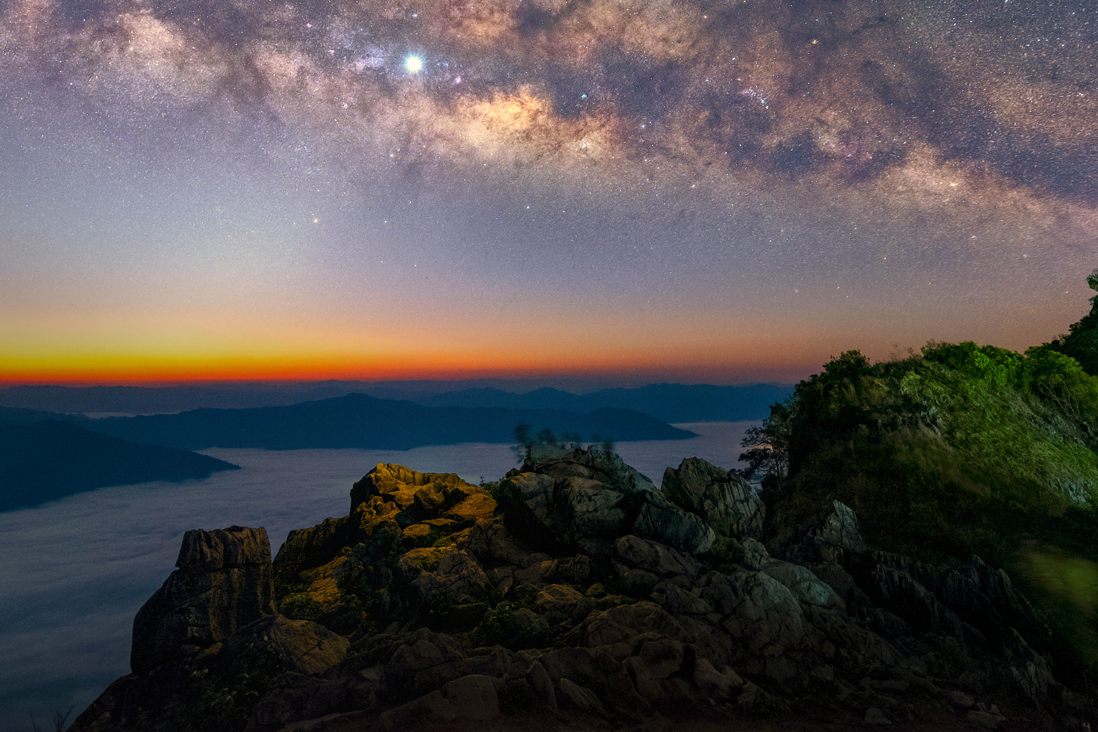 Milky Way with zodiacal light and fog rising in the morning at Doi Pha Tang
