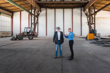 Two men standing in a factory with vr headset