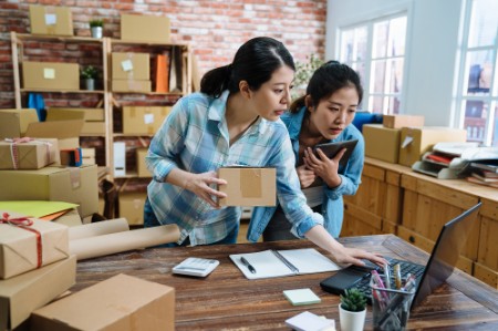 female employee using laptop working in warehouse