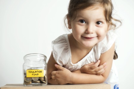 A small girl with a fund collection jar