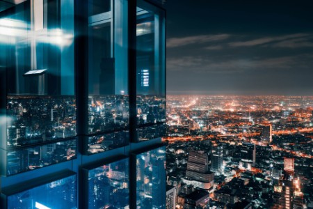 Glass office window above a glowing city at night