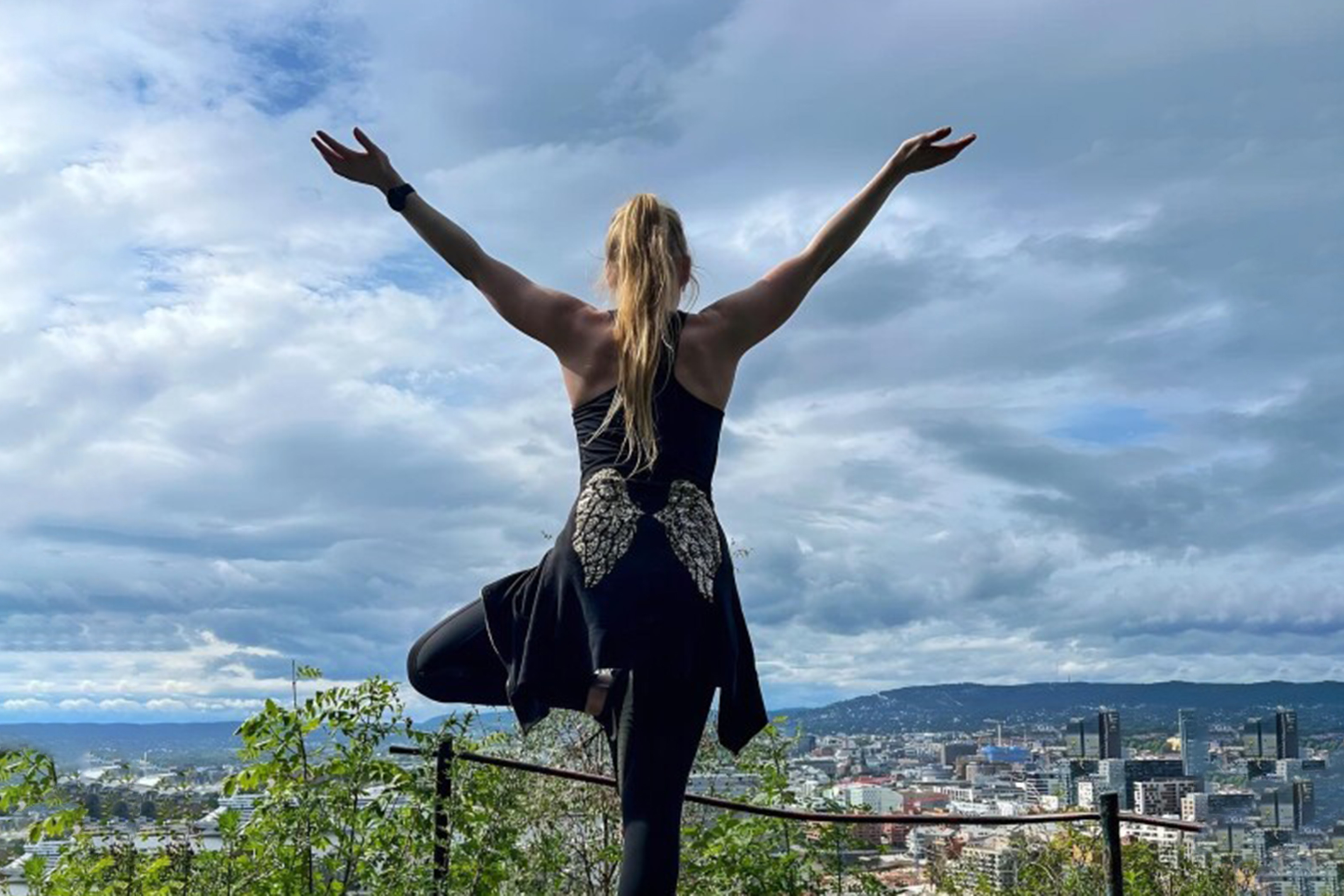 Picture of Treepose by a woman with a anglewinged hoodie and nature in the horizon.