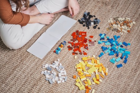 Picture of female hands playing with toys on the carpet