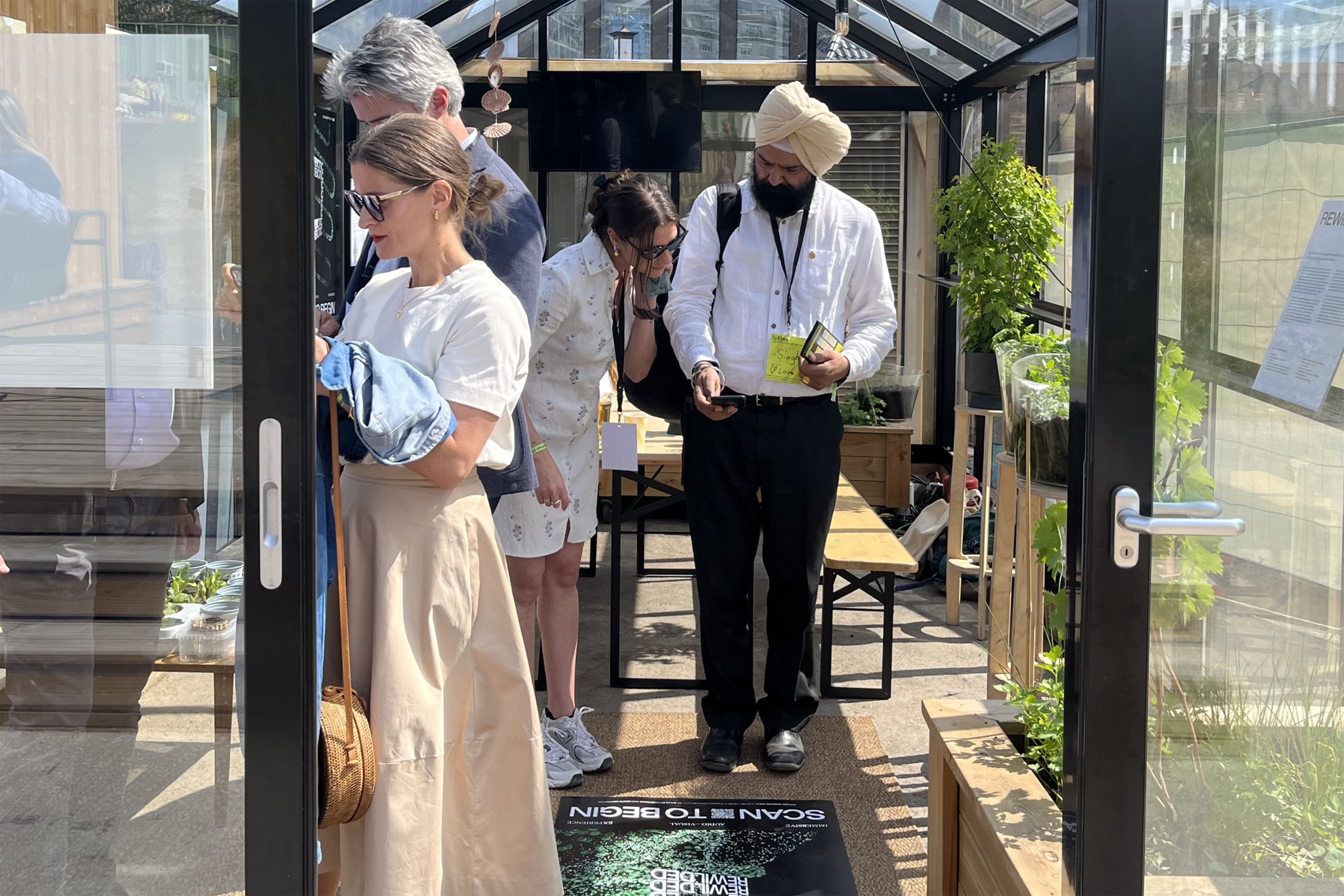 Sustainability leaders discuss Window to the Future at the greenhouse with EY teams.