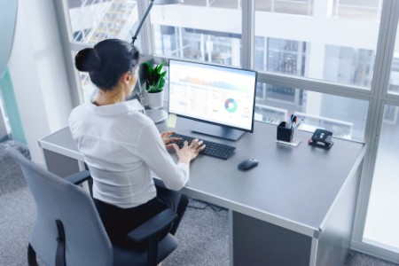 Businesswoman working on computer with financial data