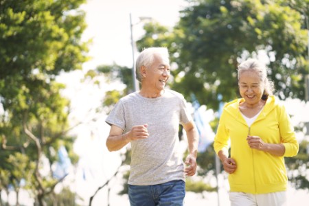 Happy Asian senior couple exercising in park