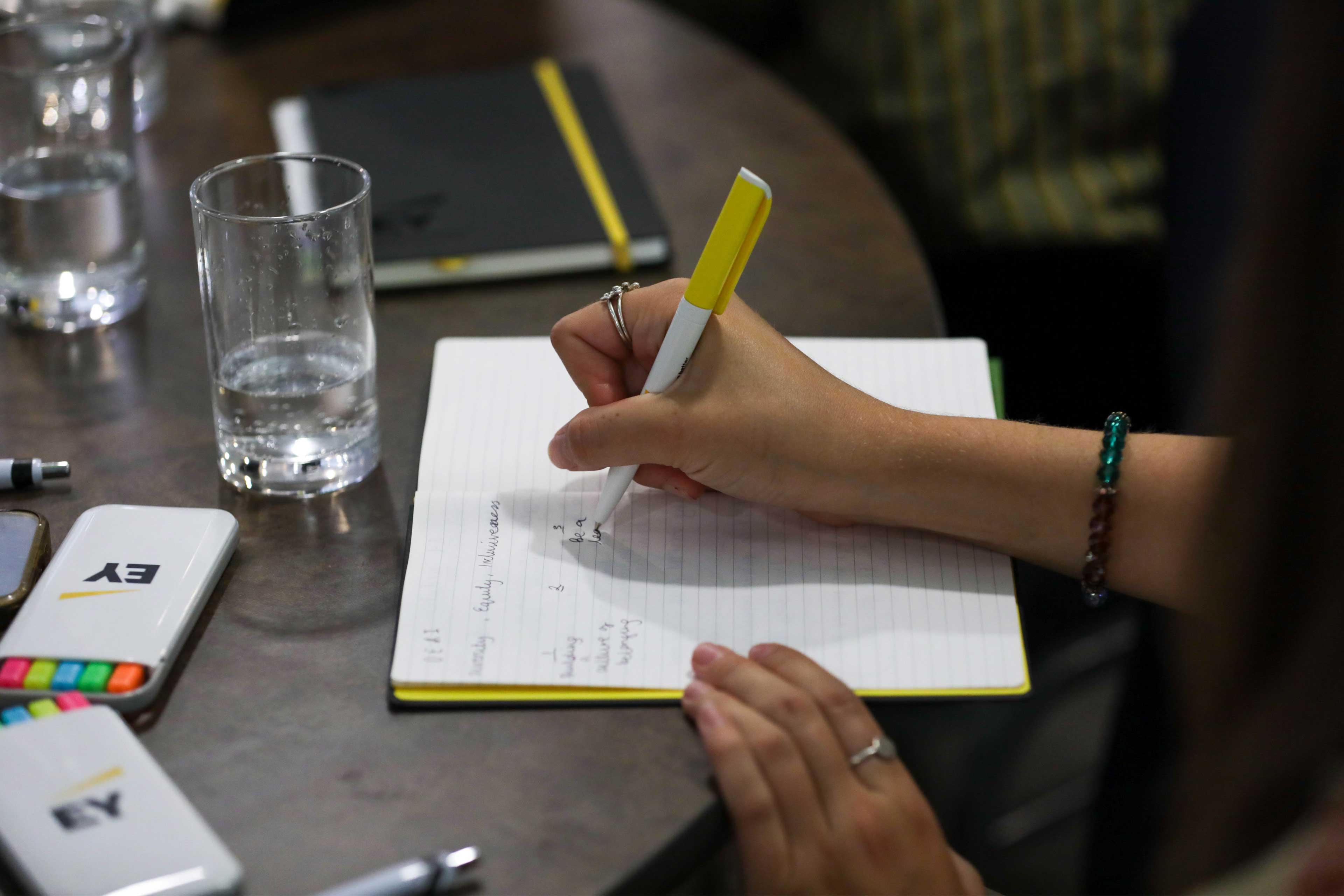 Student writing in a notebook at an event