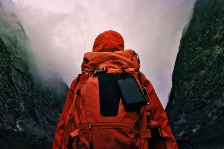 Hiker dressed in a red raincoat going for a walk