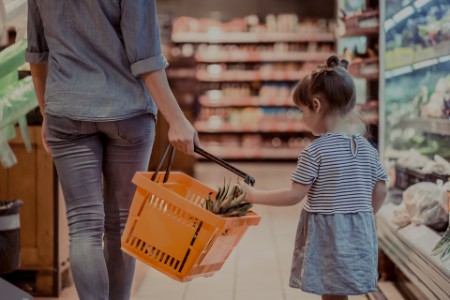 Mother and baby daughter shopping in supermarket