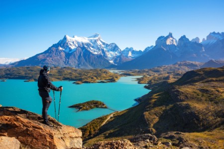 Hiker at mirador condor enjoying amazing view of Los Cuernos rocks and Lake Pehoe in Torres del Paine national park