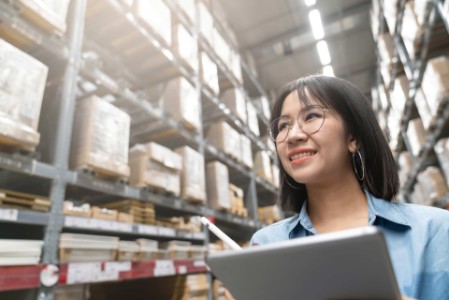 EY Young woman checking warehouse stock