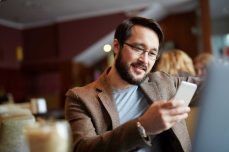 Man holding a phone sitting in a café