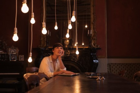 Women sitting at table with hanging light bulbs